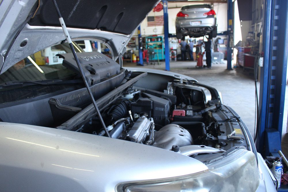 Silver SUV on a lift with hood open